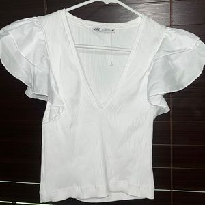 It’s a top from Zara! It’s white and has beautiful open ruffled sleeves.